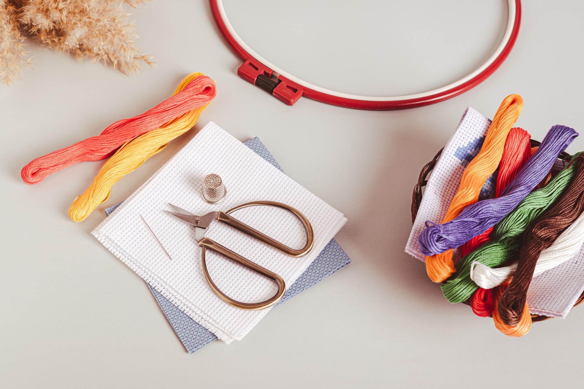 Flatlay of embroidery tools and threads